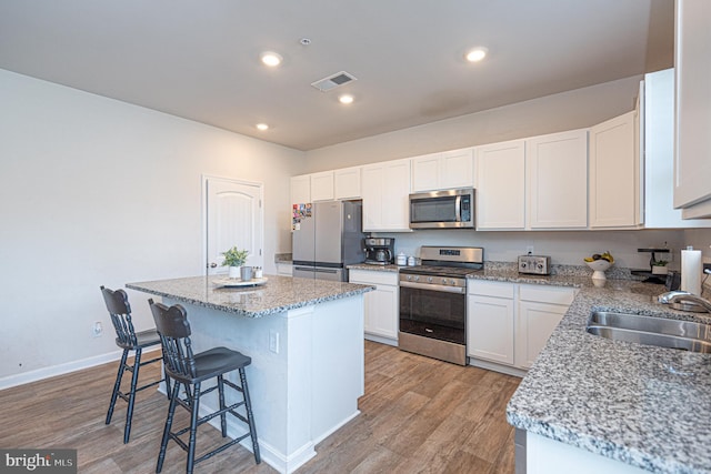 417 Lena Ln, Fruitland, MD 21826 - kitchen with stainless steel appliances, a sink, visible vents, a kitchen bar, and light wood-style floors
