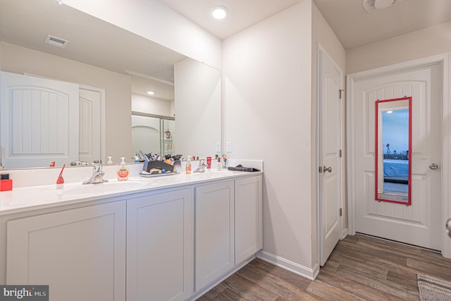 417 Lena Ln, Fruitland, MD 21826 - bathroom with wood finished floors, a sink, double vanity, baseboards, and visible vents