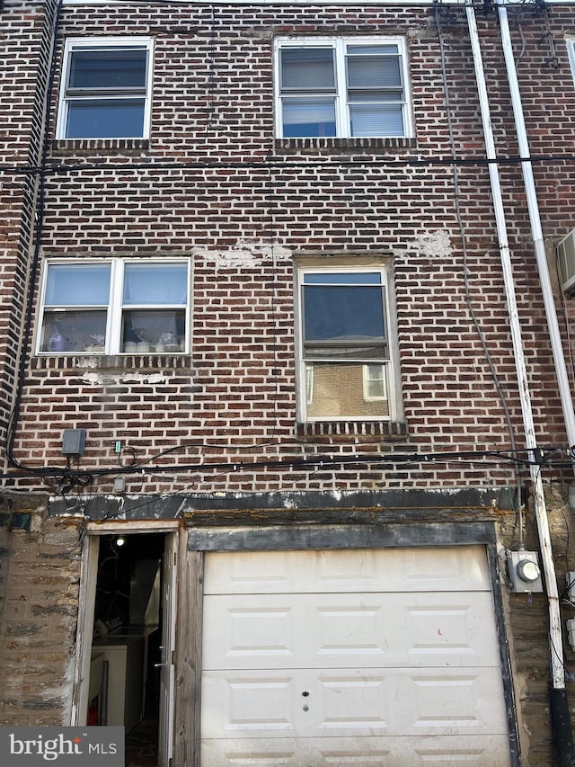 exterior space featuring electric meter and brick siding