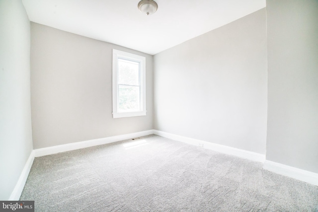 carpeted empty room with baseboards