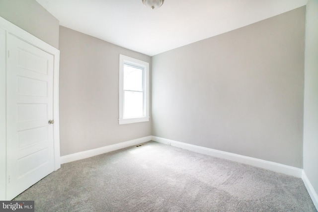 carpeted spare room with baseboards