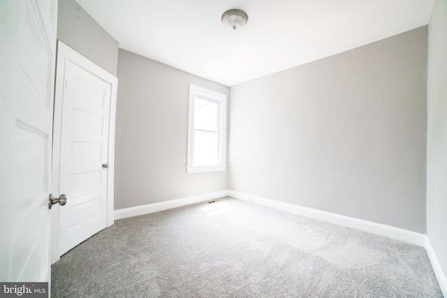 empty room featuring baseboards and carpet floors