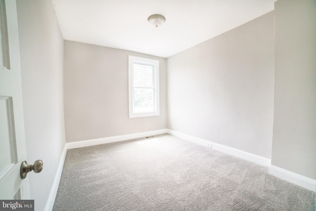 unfurnished room with baseboards and carpet floors
