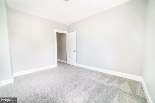 spare room featuring carpet and baseboards