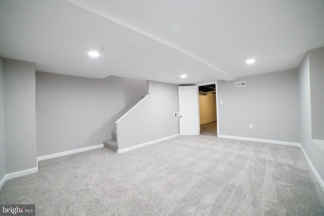 finished below grade area with visible vents, baseboards, carpet floors, and stairs