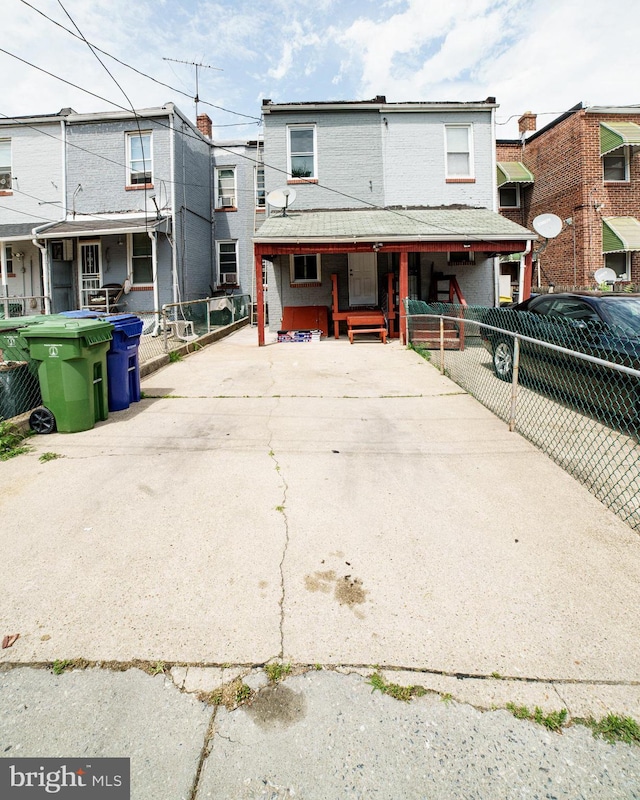 view of front of house with concrete driveway and fence