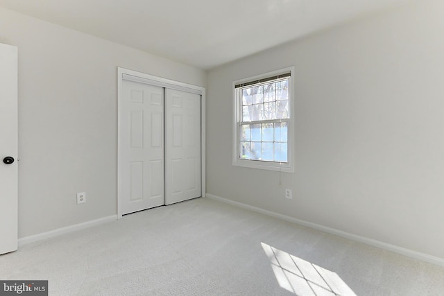 unfurnished bedroom featuring light carpet and baseboards