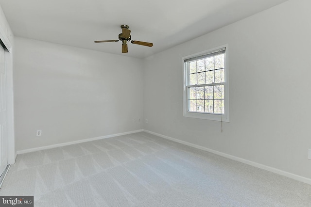 unfurnished room with light colored carpet, ceiling fan, and baseboards