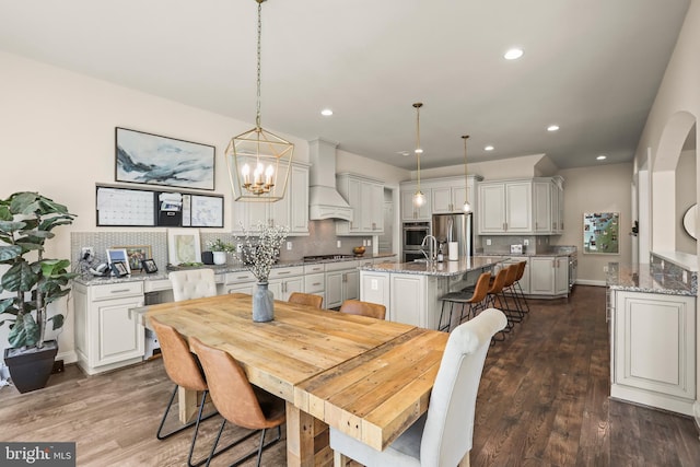 dining room with an inviting chandelier, dark wood-style floors, and recessed lighting