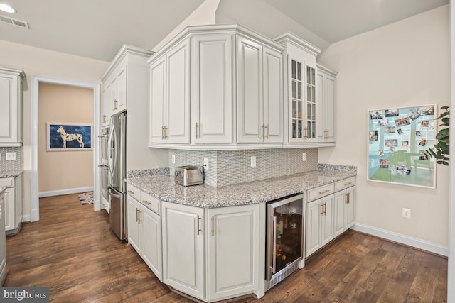 kitchen featuring baseboards, beverage cooler, visible vents, and freestanding refrigerator