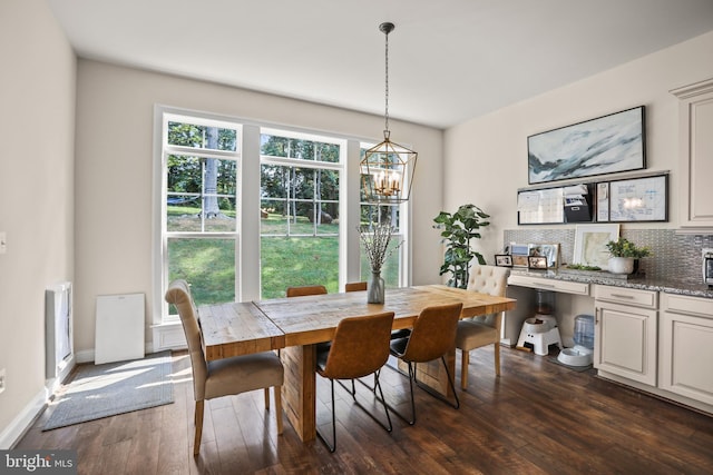 dining space featuring baseboards, dark wood-style floors, and a chandelier