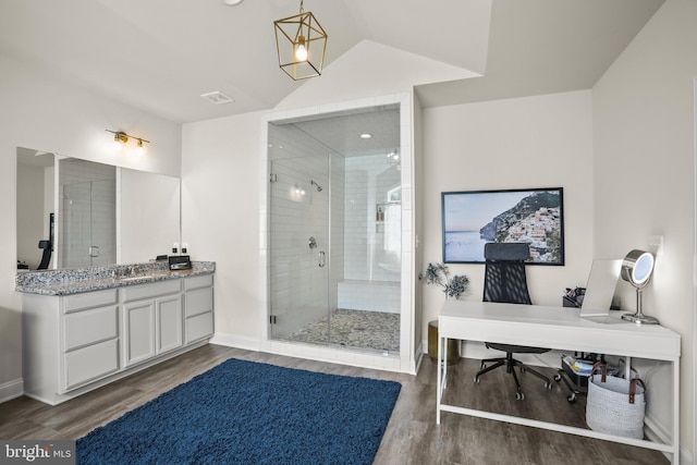bathroom featuring a shower stall, baseboards, vanity, and wood finished floors