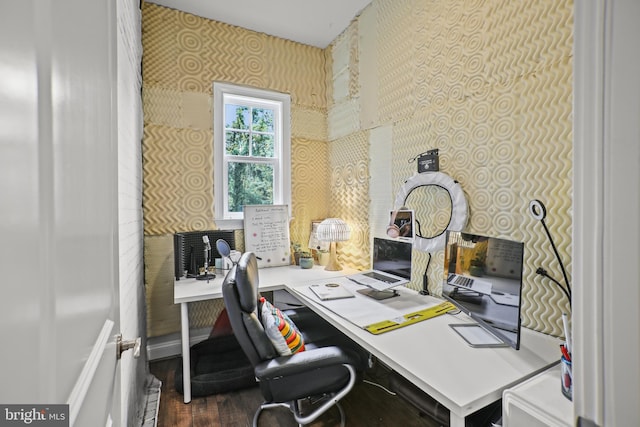 home office with wallpapered walls and wood finished floors