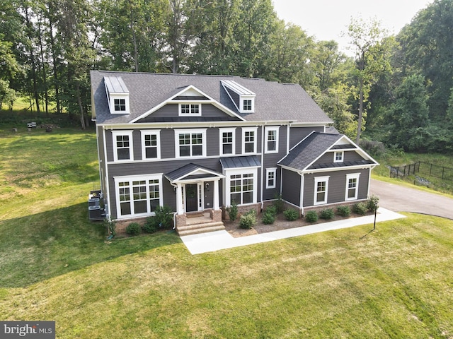 craftsman-style home with a front lawn, aphalt driveway, and a shingled roof