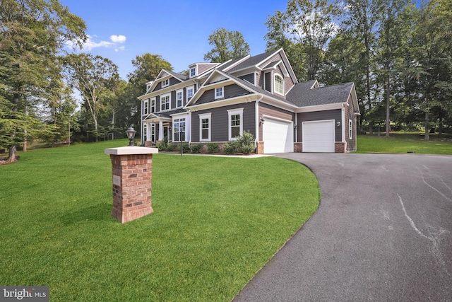 view of front of home with a front lawn, driveway, and a garage