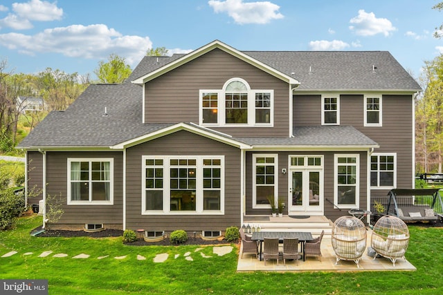 back of house with a shingled roof, a yard, and a patio