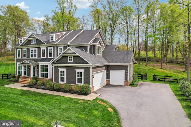 craftsman house with a garage, a front lawn, fence, and aphalt driveway