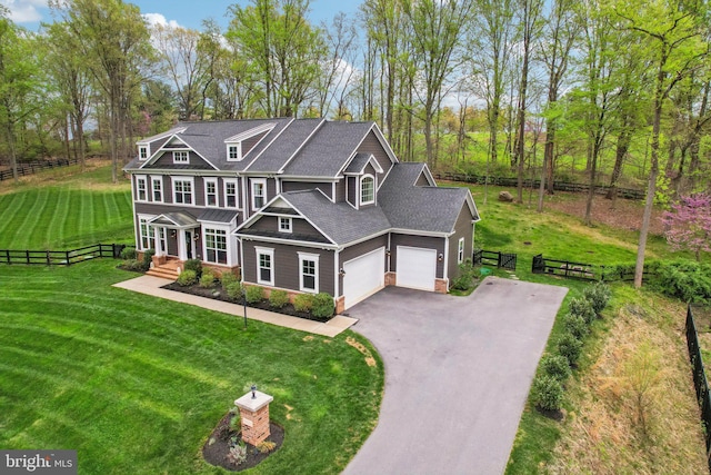 craftsman-style home featuring covered porch, driveway, a front yard, and fence