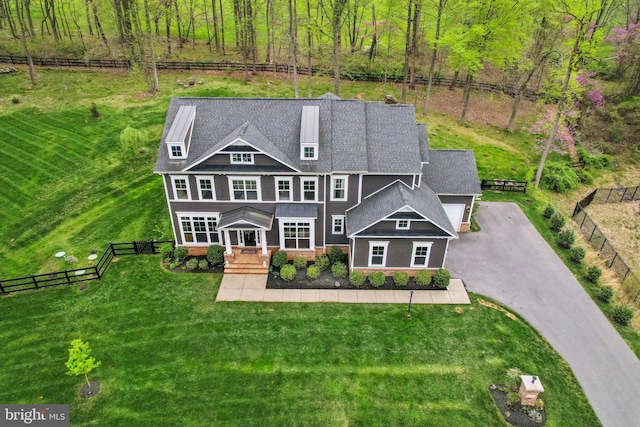 view of front of property featuring fence, aphalt driveway, a shingled roof, and a front yard