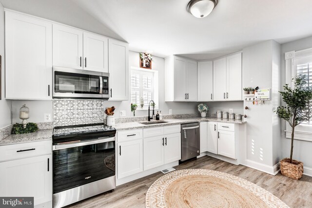 548 Uniontown Rd, Westminster, MD 21158 - kitchen featuring stainless steel appliances, light wood-style flooring, white cabinetry, and a sink