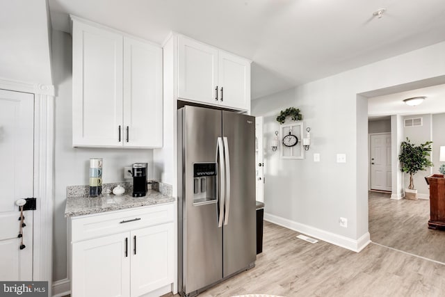 548 Uniontown Rd, Westminster, MD 21158 - kitchen with white cabinets, light wood-style floors, stainless steel fridge, and visible vents