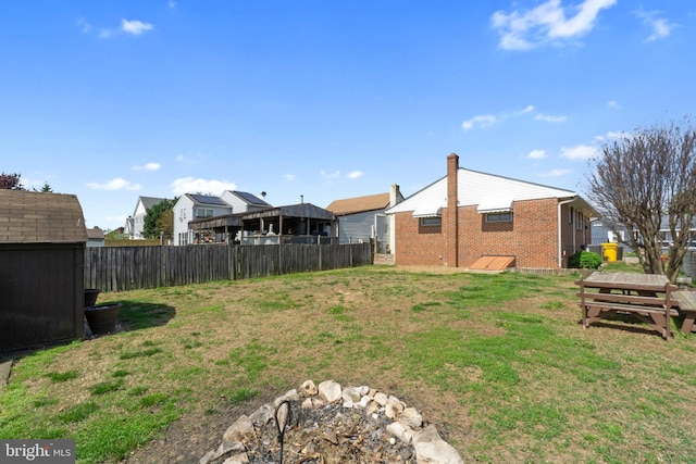 view of yard featuring fence, an outbuilding, a storage shed, and a residential view