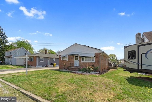 bungalow featuring entry steps, a front lawn, and brick siding