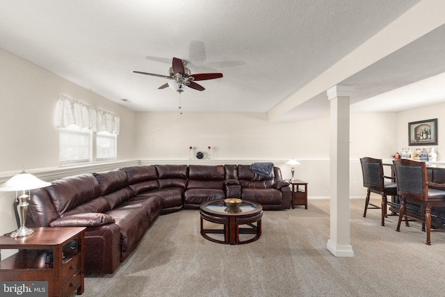living room featuring decorative columns, a ceiling fan, and carpet flooring