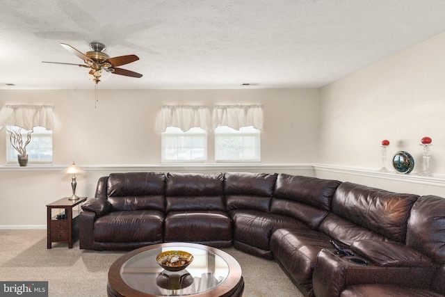 living room with carpet floors, a ceiling fan, and plenty of natural light