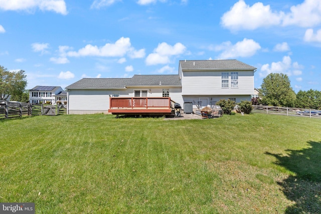 back of property featuring a lawn, a deck, central AC, and a fenced backyard