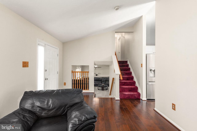 living area featuring stairs, baseboards, lofted ceiling, and hardwood / wood-style flooring