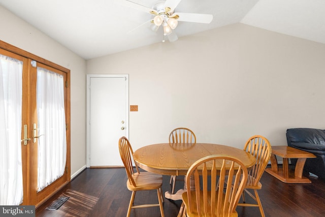 dining room featuring ceiling fan, visible vents, baseboards, wood finished floors, and vaulted ceiling