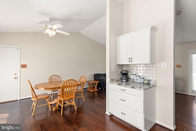 dining space featuring ceiling fan, dark wood-type flooring, and lofted ceiling