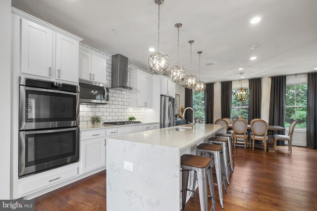 1353 Powhatan St, Alexandria, VA 22314 - kitchen with wall chimney range hood, appliances with stainless steel finishes, tasteful backsplash, recessed lighting, and light countertops