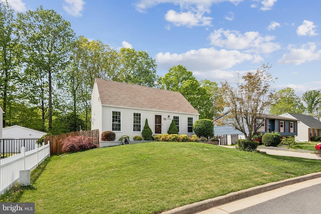 view of front of home with fence, a front lawn, and roof with shingles