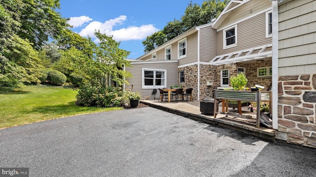 307 Homestead Rd, Hershey, PA 17033 - back of property featuring a lawn, stone siding, and a patio