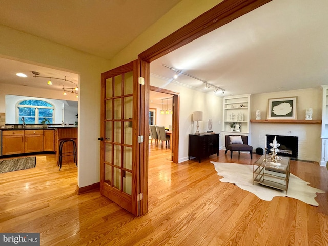 307 Homestead Rd, Hershey, PA 17033 - interior space with baseboards, built in features, light wood-style floors, a brick fireplace, and track lighting