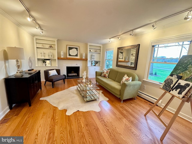 307 Homestead Rd, Hershey, PA 17033 - living area featuring a baseboard heating unit, built in features, wood finished floors, track lighting, and ornamental molding