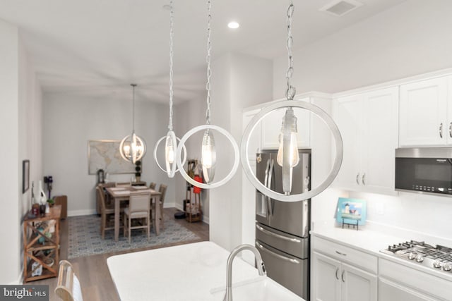 2537 Monarch Way, Bel Air, MD 21015 - kitchen with stainless steel appliances, white cabinets, light countertops, wood finished floors, and a chandelier