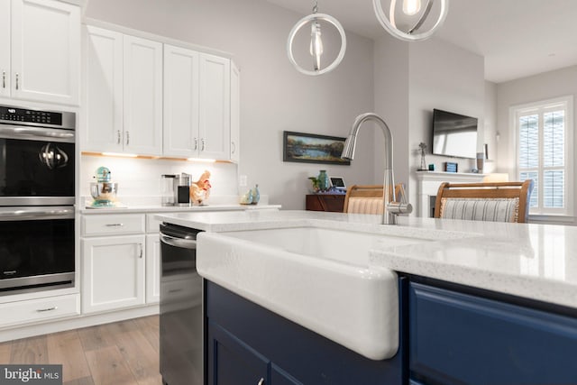 2537 Monarch Way, Bel Air, MD 21015 - kitchen with appliances with stainless steel finishes, pendant lighting, light wood finished floors, white cabinets, and light stone counters