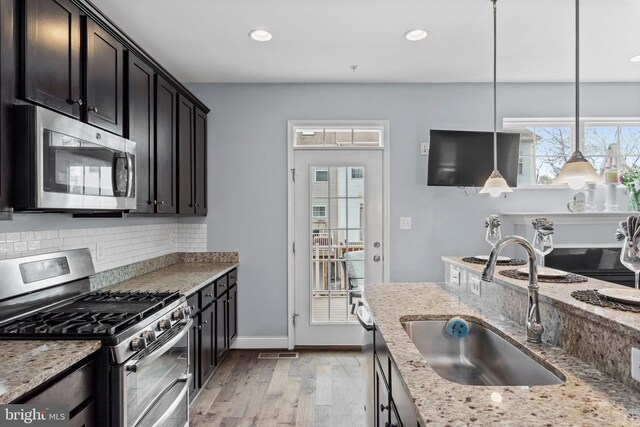 1614 Belle Dr, Annapolis, MD 21401 - kitchen with stainless steel appliances, light wood-style floors, a sink, and light stone counters