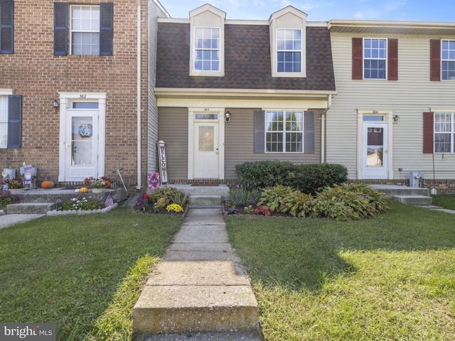 multi unit property featuring mansard roof, a shingled roof, and a front yard