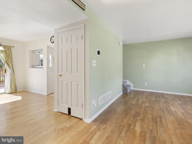 spare room with baseboards, visible vents, and light wood finished floors