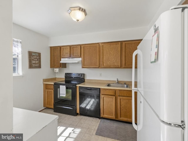 kitchen featuring brown cabinets, a sink, light countertops, black appliances, and under cabinet range hood
