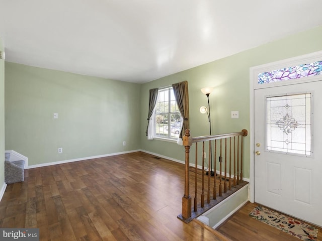 foyer with baseboards, wood finished floors, and stairway