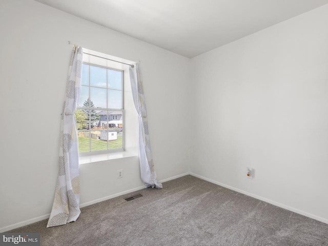 unfurnished room featuring visible vents, carpet, and baseboards