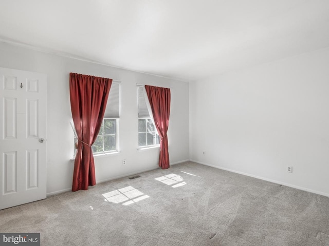 carpeted empty room with visible vents and baseboards