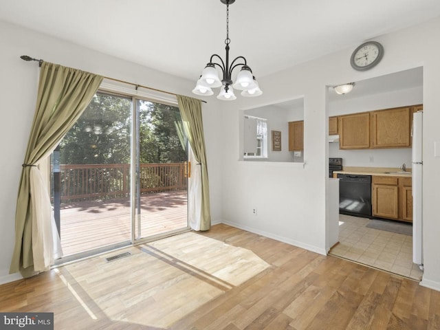 unfurnished dining area with visible vents, a sink, baseboards, light wood finished floors, and an inviting chandelier