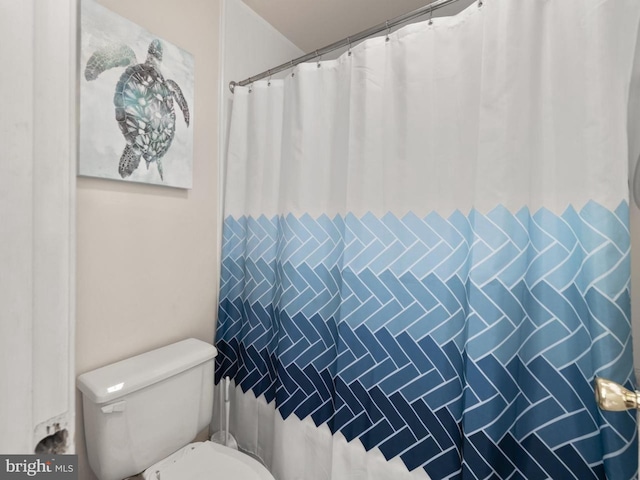 full bathroom featuring toilet and curtained shower
