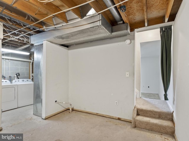 basement with baseboards, washer and clothes dryer, and stairway